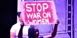 Woman holds poster written 'Stop war on women'