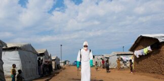 WHO says Ebola outbreak in Uganda is over, as cases rise in Congo Displaced people observe a health worker in full personal protective equipment disinfecting an area during the burial of suspected Ebola victims in a camp in eastern Democratic Republic of Congo.